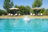 Bildet viser basseng, parasoller og solsenger på feriebosted ved Pisa i Italia.