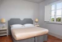 Bildet viser soverom med dobbeltseng i feriebolig på vingård med restaurant i Toscana.