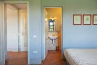 Bildet viser soverom med bad på gårdshotell nært Pisa i Toscana.