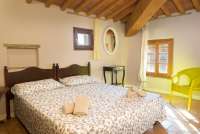 Bildet viser ett av soverommene i leiligheten Colombaia på vingården Borgo Etruschi, formidlet av SiToscana.