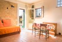 Bildet viser oppholdsrom og spiseplass i ferieleiligheten Nido på vingården Borgo Etruschi. Formidlet av SiToscana.