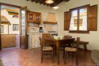 Lucciola med oppholdsrom og kjøkken. Bildet viser oppholdsrom med kjøkken i feriebolig på vingård i Toscana.