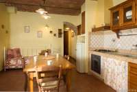 Cavallino har ekstra sengeplass i oppholdsrom/kjøkken. Bildet viser kjøkken med spisebord i feriehus på vingård i Toscana.