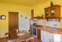 Cecco Bilenco har direkte utgang til egen uteplass fra oppholdsrom/kjøkken. Bildet viser kjøkken med spisebord i feriehus på familievennlig vingård i Toscana.