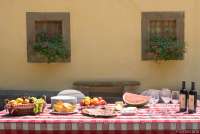 Bildet viser langbord utenfor villa med basseng i Toscana.