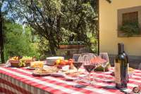 Bildet viser langbord på terrasse utenfor stort feriehus nært Pisa i Italia.