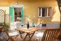 Uteplassen til Roberto, med leiligheten i bakgrunnen. Bildet viser feriehus med uteplass i badeby i Toscana.