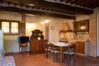 Tre Civette har sovesofa og plass til ekstraseng i oppholdsrom/kjøkken. Bildet viser kjøkken med spisebord i feriebolig på vingård i hjertet av Toscana.