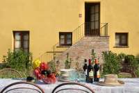 Domani è Festa har uteplass på bakkeplan. Trappa opp til leiligheten i bakgrunnen. Bildet viser oppdekket bord på uteplass utenfor ferieleilighet midt mellom Pisa og Firenze.