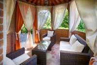 Bildet viser lysthus med sofa på feriebosted ved landsby i Toscana.